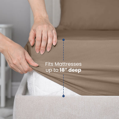 Hands adjusting a fitted sheet on a mattress, indicating it fits mattresses up to 18 inches deep.