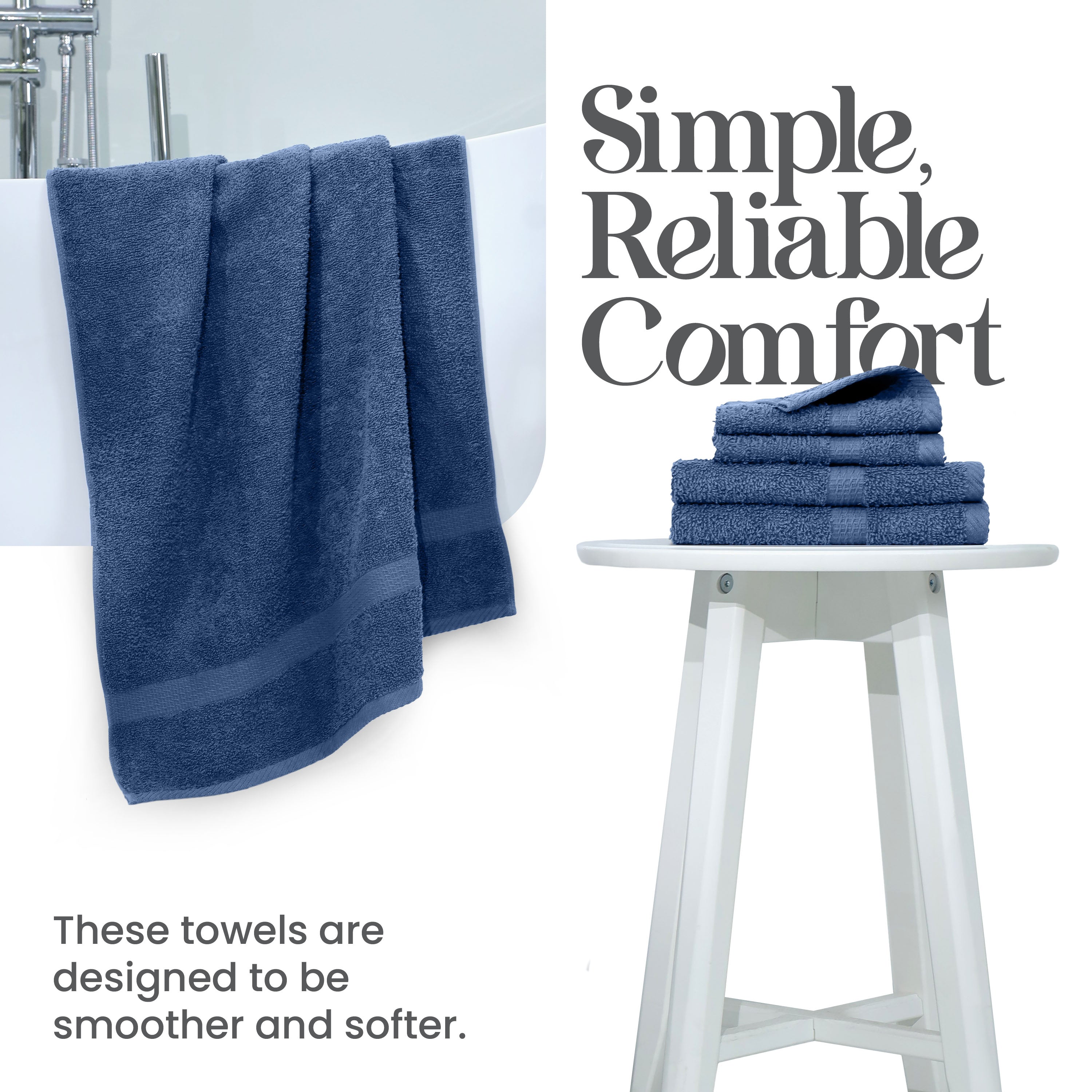 Navy towels hanging over a white tub with a stack of folded towels on a white stool.