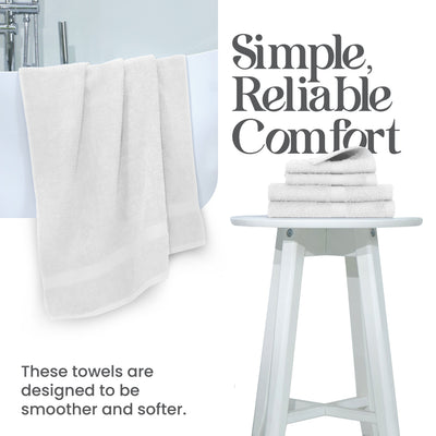 White towels hanging over a bathtub, with a stack of folded towels on a white stool beside them.