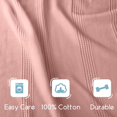 Textured cotton blanket in soft pink with care instructions and fabric details displayed.
