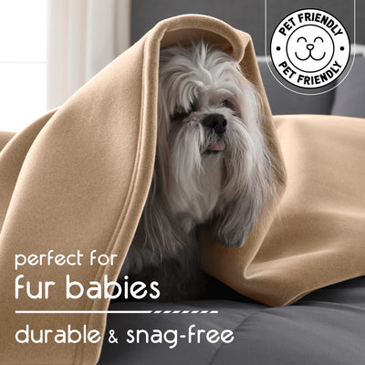 A small dog is partially covered by a beige blanket on a couch, with a light background and a pet-friendly label.