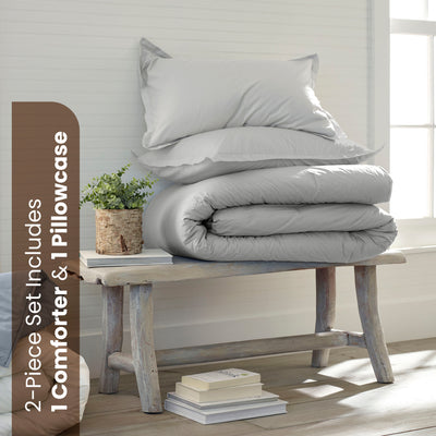 Gray comforter set with one comforter and one pillowcase displayed on a wooden bench with a small plant and books.
