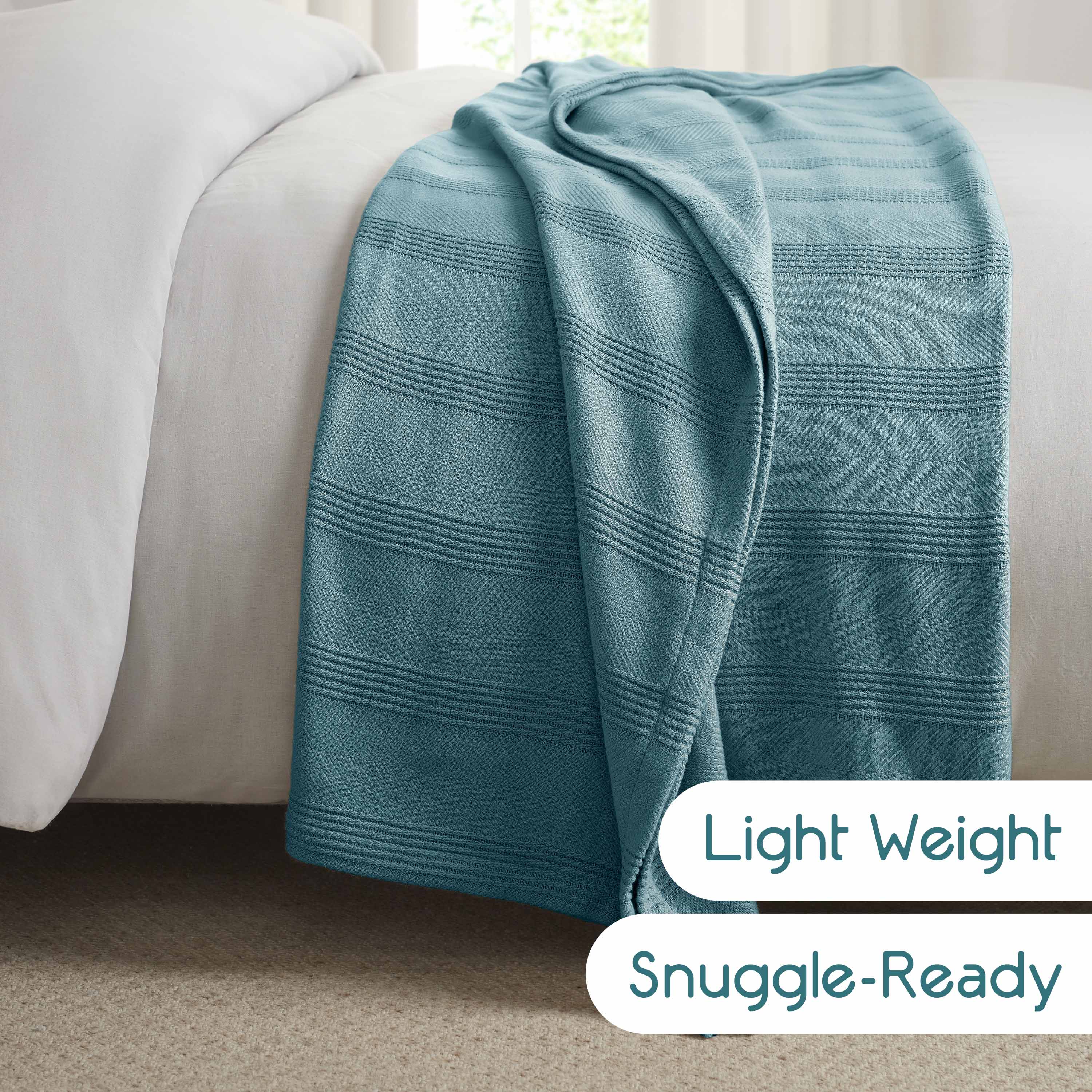 A light blue cotton blanket with textured stripes draped over a bed.