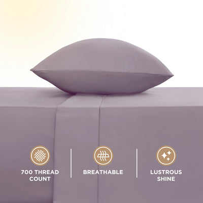 Light purple pillow resting on a smooth sheet, with icons indicating 700 thread count, breathability, and shine.