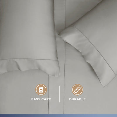 Light gray Supima cotton sheet set with two pillows, featuring smooth fabric and stitched edges.