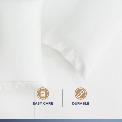 White Supima cotton sheet set with ruffled pillowcases, featuring easy care and durability icons.