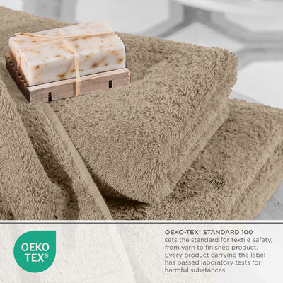 Soft beige towels stacked with a bar of soap on a wooden soap dish, featuring Oeko-Tex certification label.