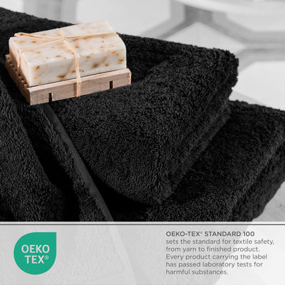 Black towels stacked with a bar of soap on a wooden soap dish, featuring Oeko-Tex certification information.