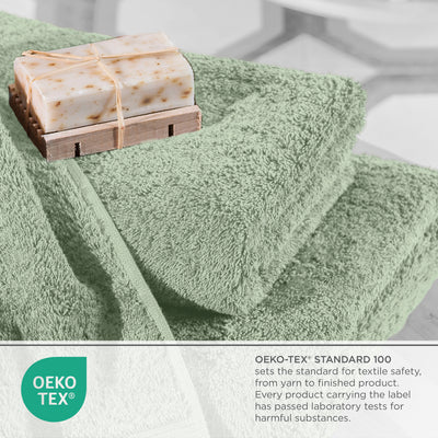 Soft green towels stacked with a bar of soap on a wooden soap dish, featuring Oeko-Tex certification label.