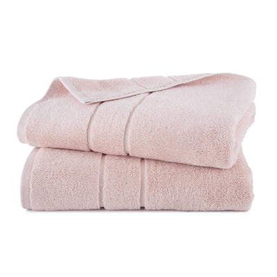 Two stacked bath towels in a soft pink color with a textured surface.