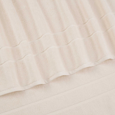 Set of four wash cloths in a soft, textured fabric with a light beige color.