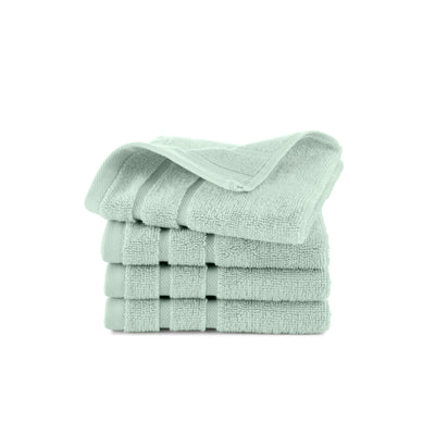Four stacked wash cloths in a soft mint green color with a textured surface.