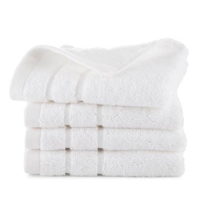 Four stacked white wash cloths with a textured surface.