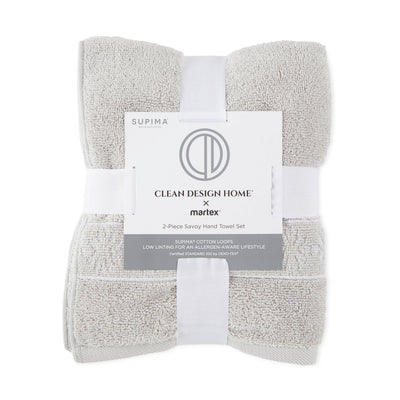 Two-piece hand towel set in light gray, featuring Supima cotton loops and a branded label.
