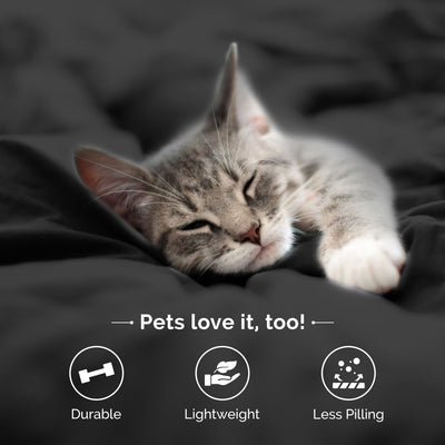 A sleeping gray tabby cat rests on a dark bedspread, with icons indicating durability, lightweight, and less pilling.