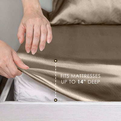 Hands adjusting a satin sheet on a mattress, with text indicating it fits mattresses up to 14 inches deep.
