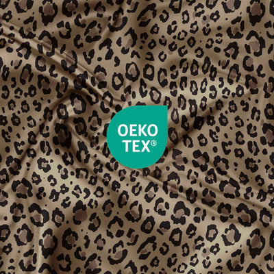 Satin fabric with a leopard print pattern and an Oeko-Tex certification logo in the corner.