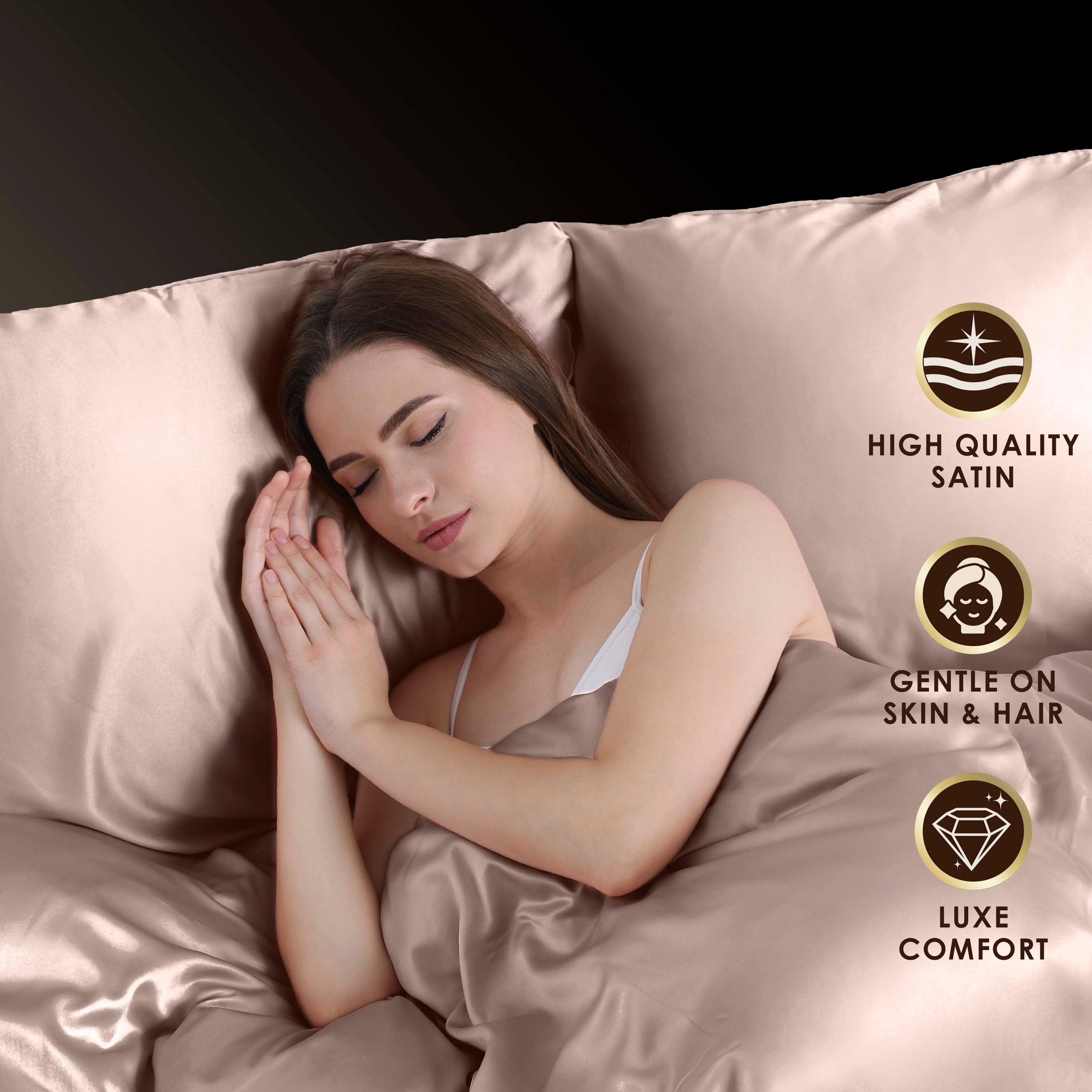 A woman sleeps peacefully on satin sheets, with her hands clasped near her face.