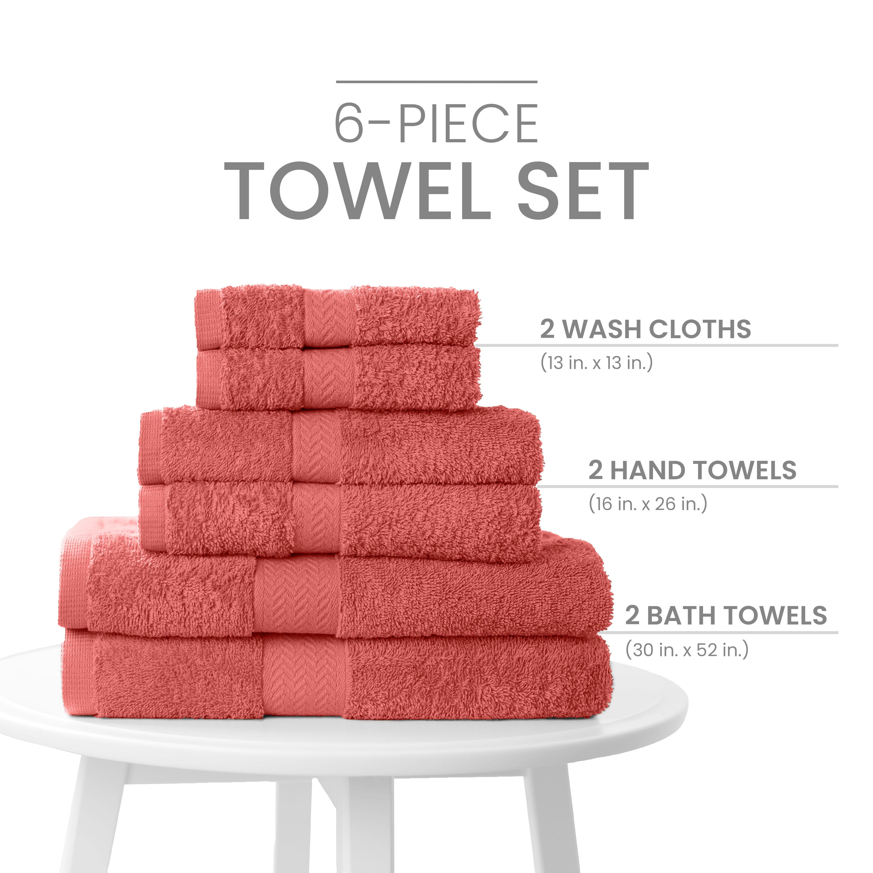 Stack of six coral towels including two wash cloths, two hand towels, and two bath towels on a white table.
