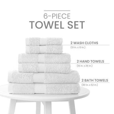 Six-piece towel set stacked on a white table, including two wash cloths, two hand towels, and two bath towels.