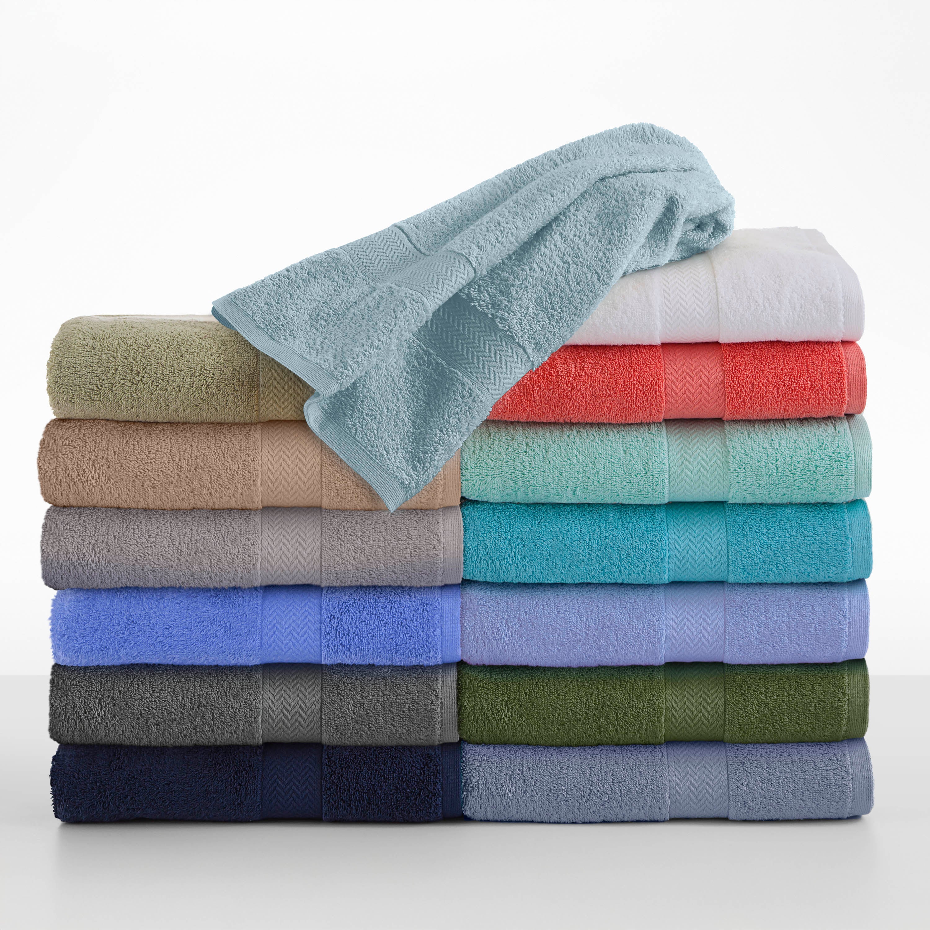 Stack of assorted towels in various colors, including beige, blue, green, and coral, with a light blue towel on top.