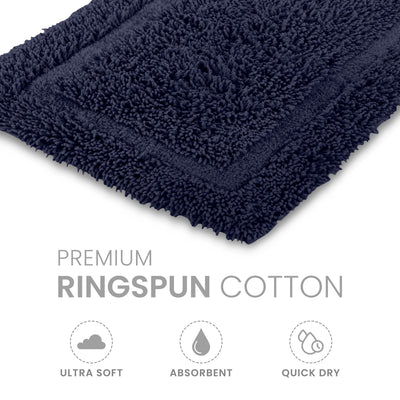 Navy blue bath rug made of ringspun cotton with a textured surface and bordered design.