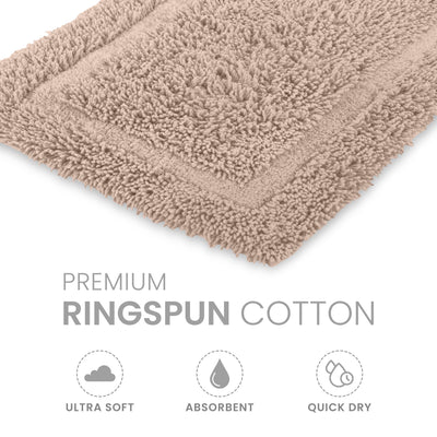 Beige bath rug with a textured surface and bordered design, made from ringspun cotton.