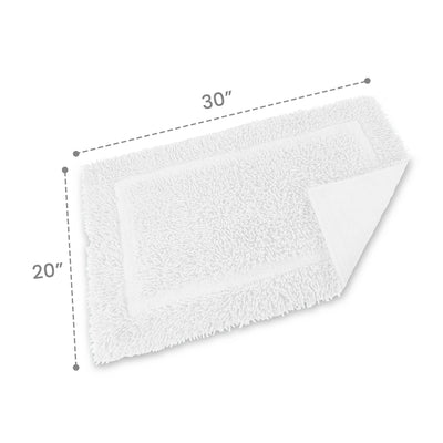 White ringspun cotton bath rug measuring 30 inches by 20 inches with a textured surface and a bordered design.