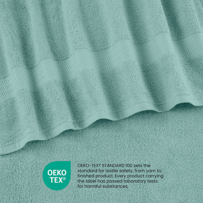 A close-up of soft, textured towels in a light teal color with a decorative woven band.