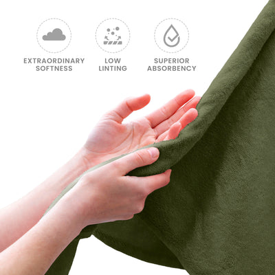 Hands holding a soft, green towel with a textured surface.