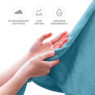 Hands holding a soft, turquoise towel, showcasing its texture and quality.