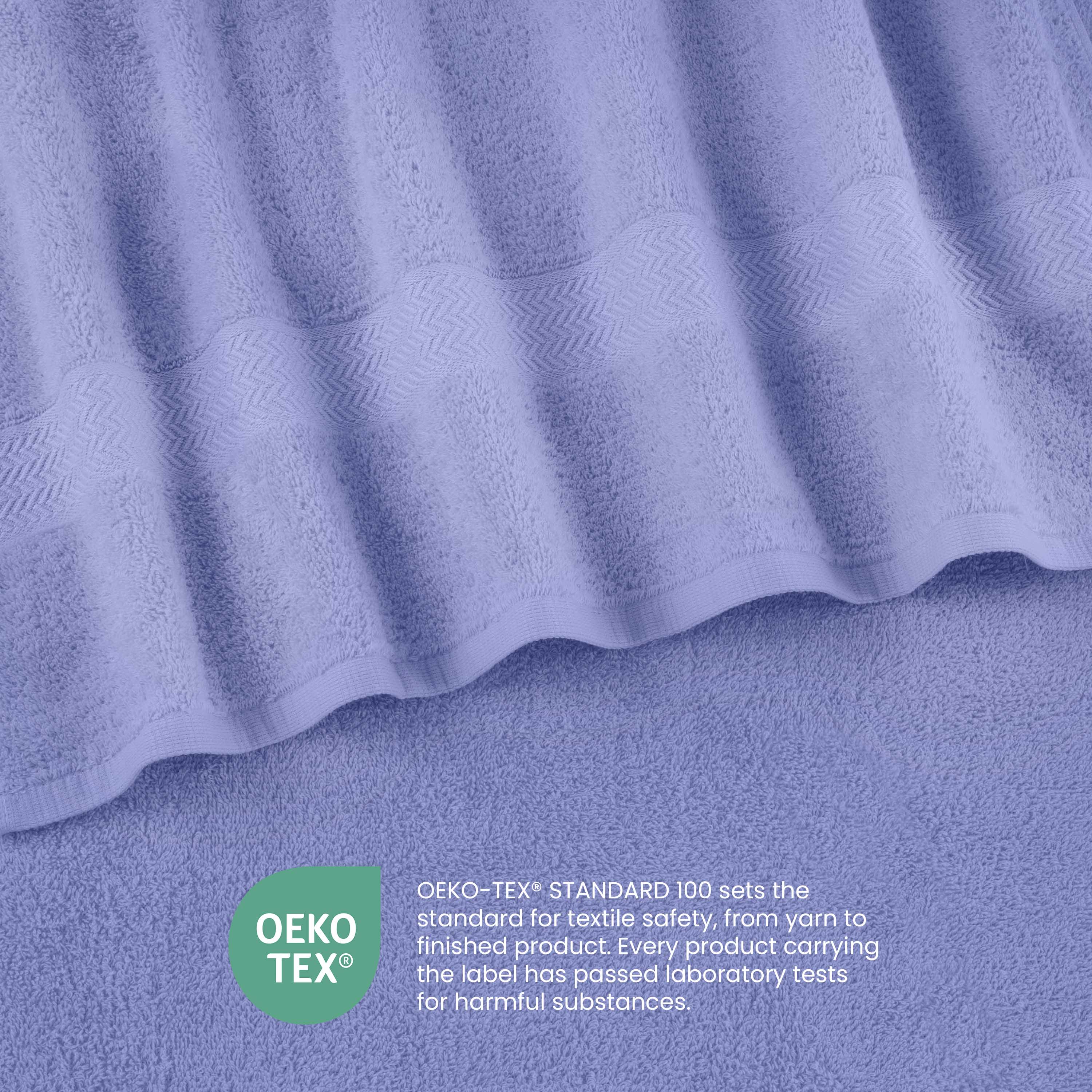 Light purple towels with a textured stripe design, featuring an Oeko-Tex certification label for textile safety.