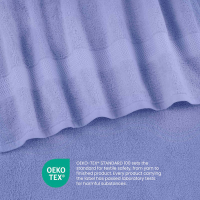 Light purple towels with a textured stripe design, featuring an Oeko-Tex certification label for textile safety.