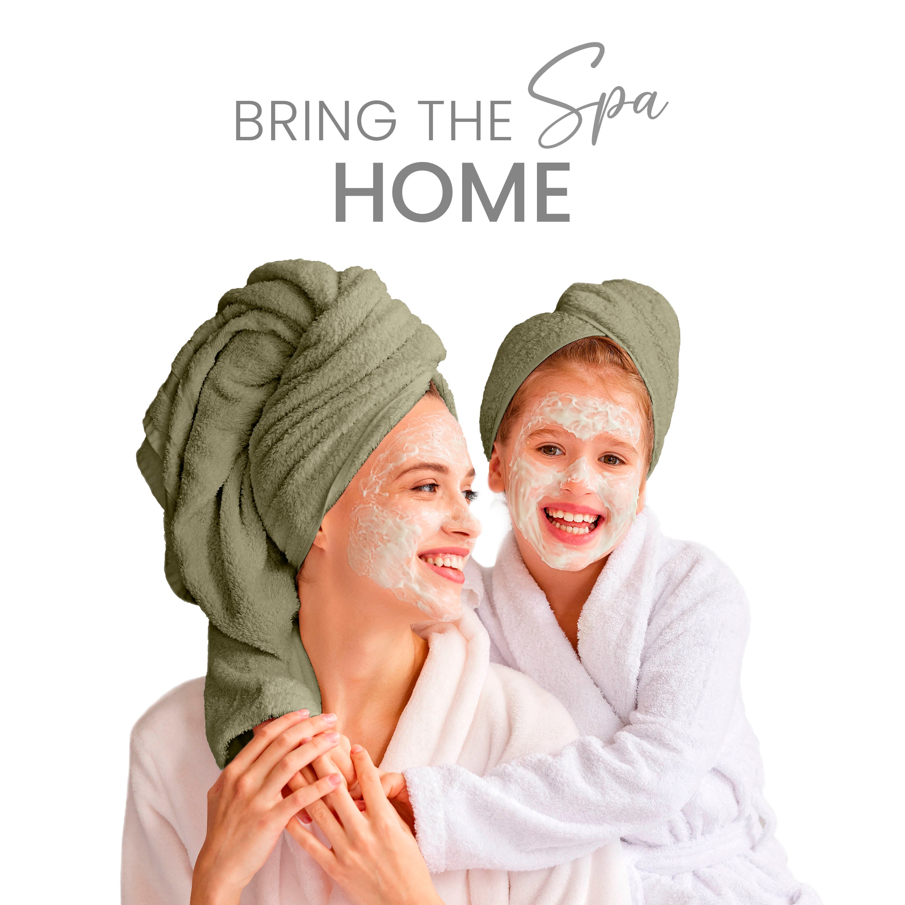 Two women, one adult and one child, wearing towels on their heads and bathrobes, smiling with facial masks on.