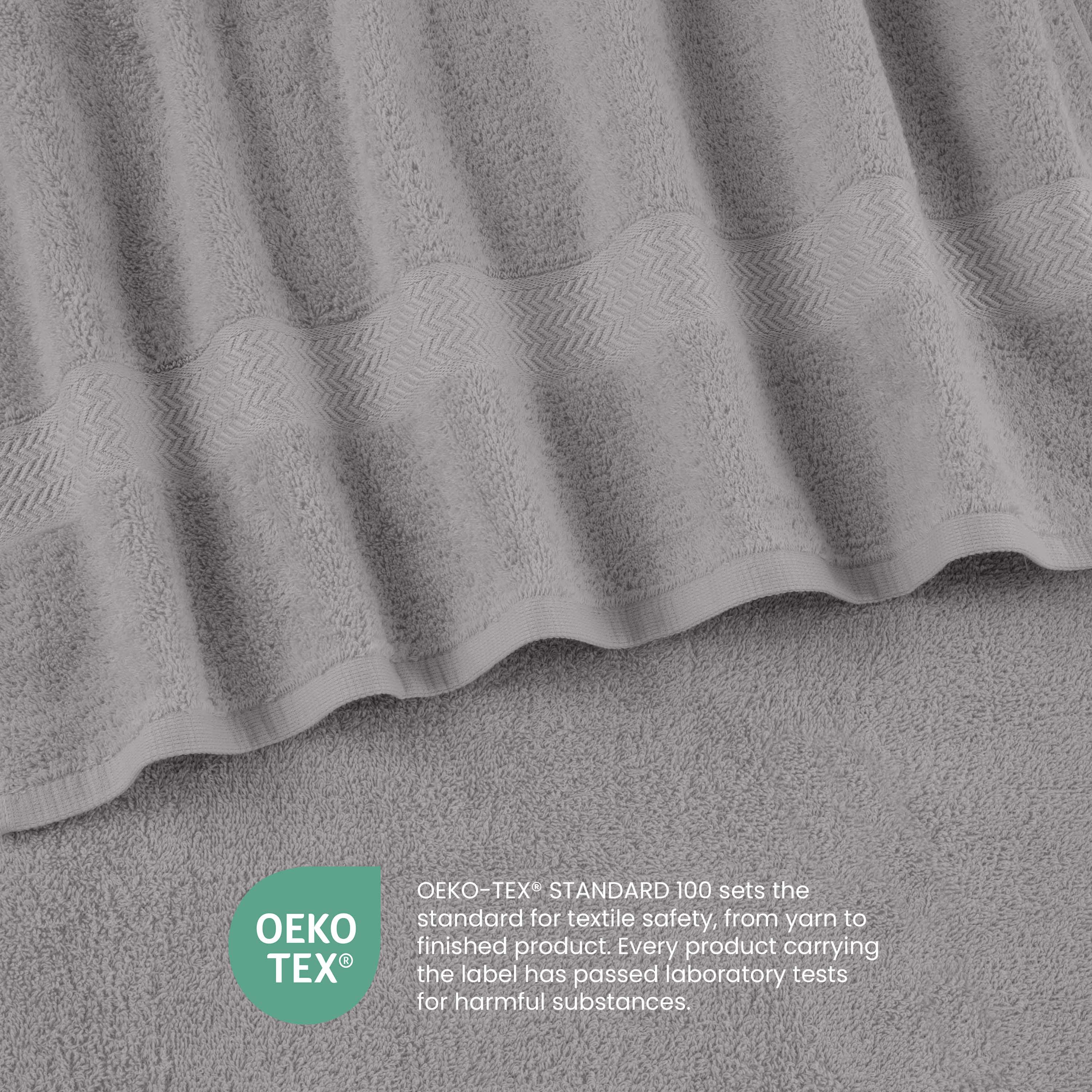 Gray towels with a textured pattern and a label indicating Oeko-Tex certification for textile safety.