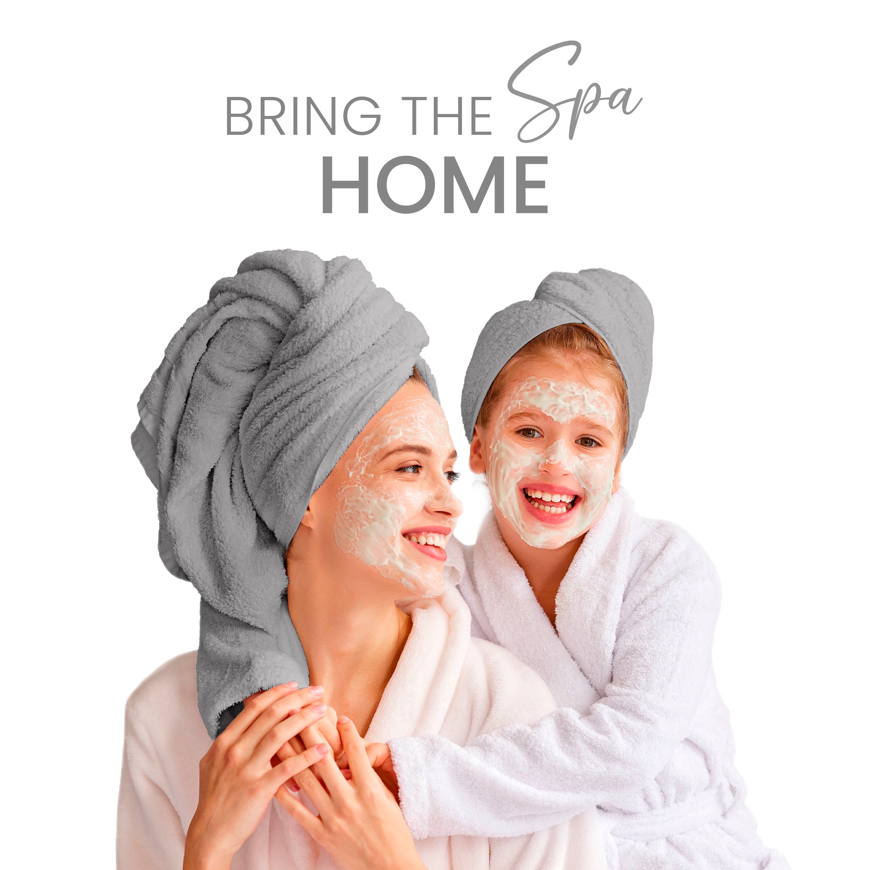 Two women, one adult and one child, wearing towels and robes, smiling with facial masks on.