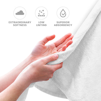 Hands holding a soft, white towel, showcasing its texture and quality.