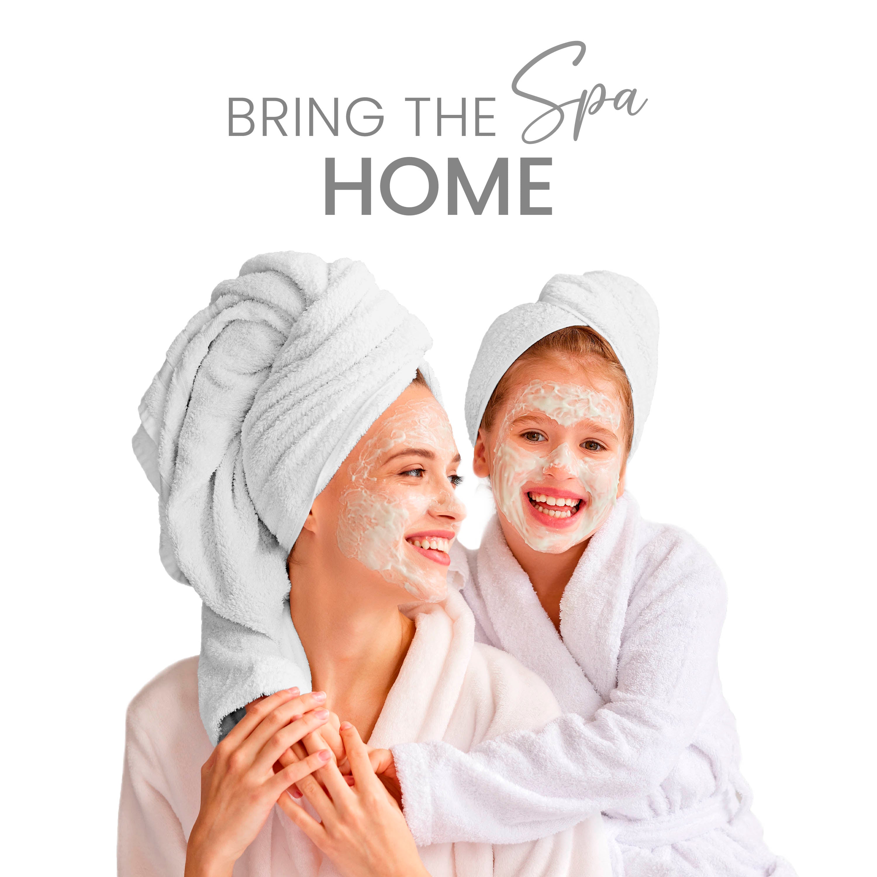 Two people with towels on their heads and facial masks, wearing white robes, smiling together.