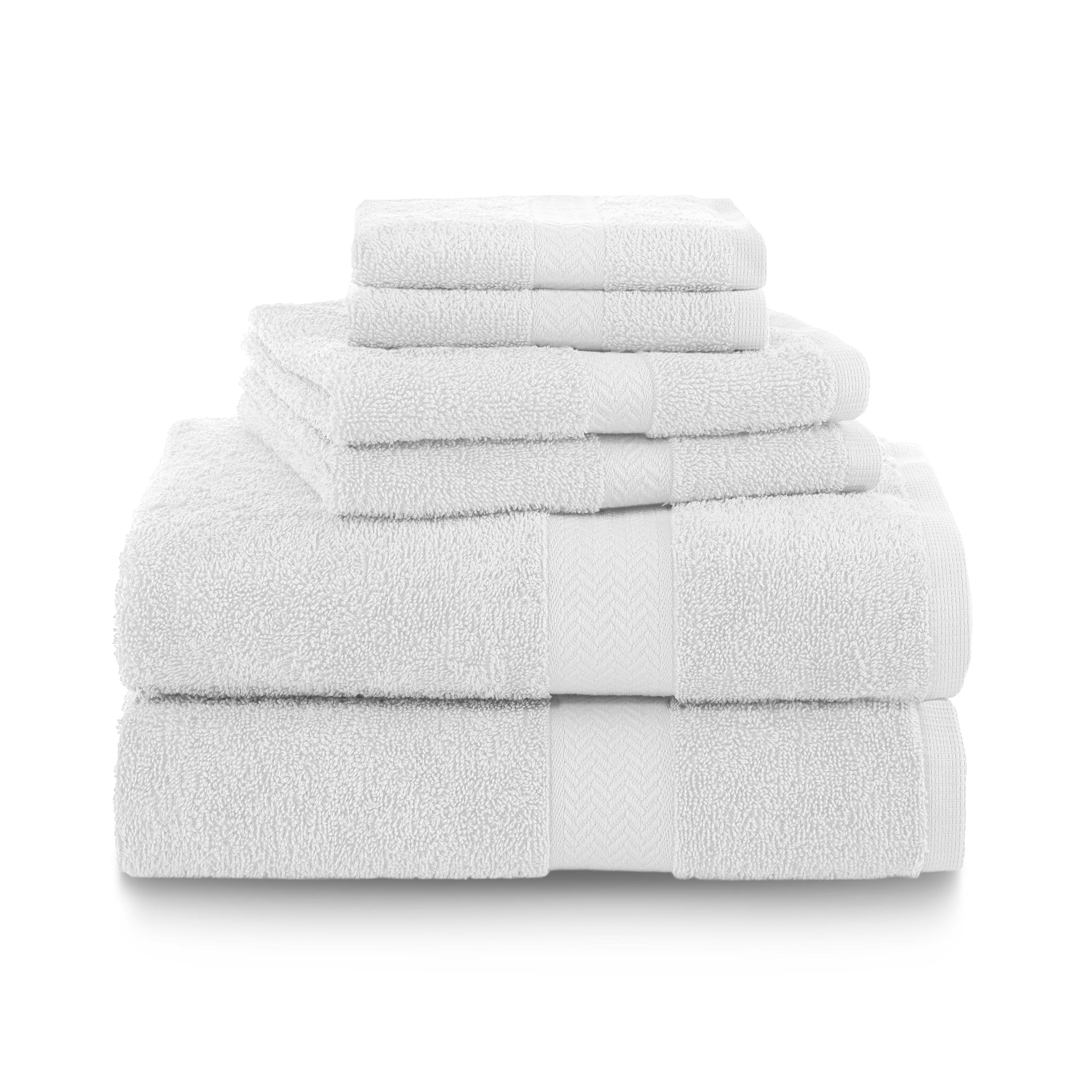 Six white towels stacked neatly, including bath, hand, and washcloth sizes.