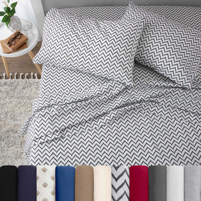 Neatly made bed with chevron white bedding in a bedroom setting.