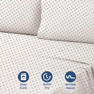 Light-colored sheet set with a geometric pattern, featuring two pillows and visible care icons.