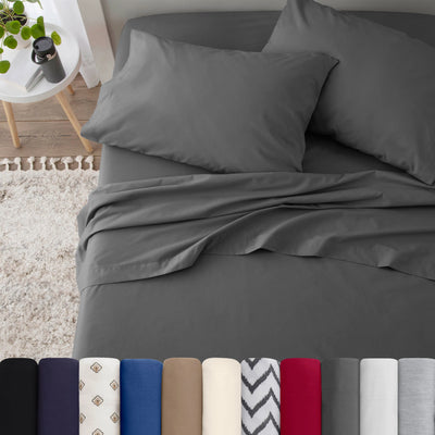 Neatly made bed with grey bedding in a bedroom setting.