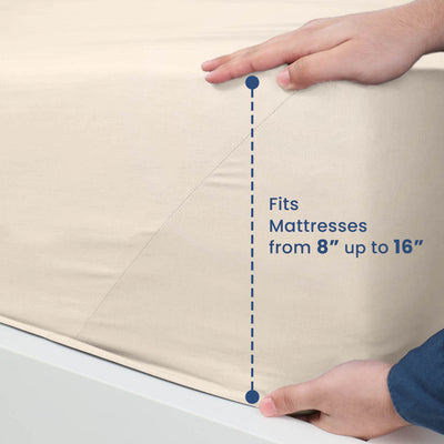 Beige fitted sheet being adjusted on a mattress, indicating it fits mattresses from 8" to 16" thick.