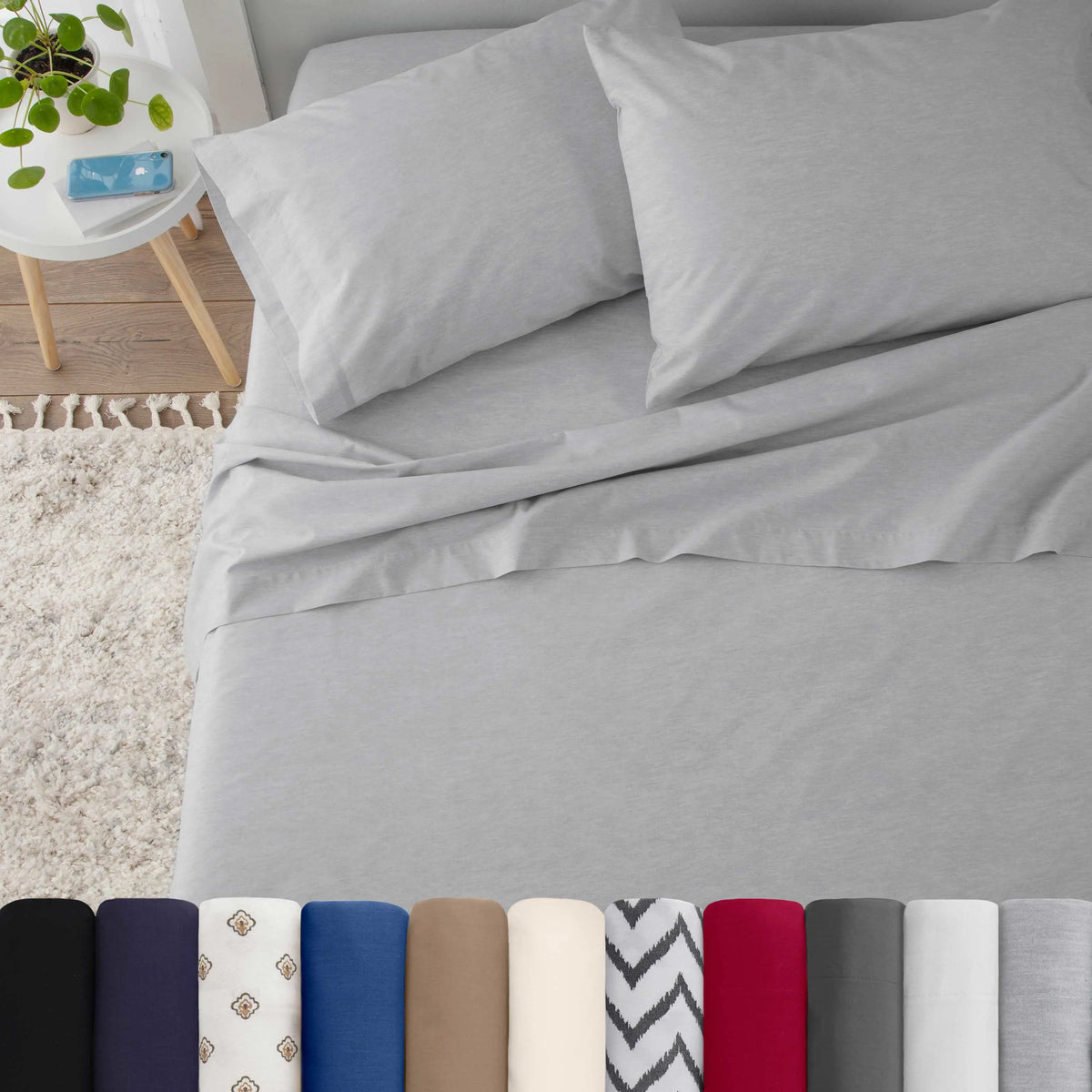 Neatly made bed with light grey bedding in a bedroom setting.