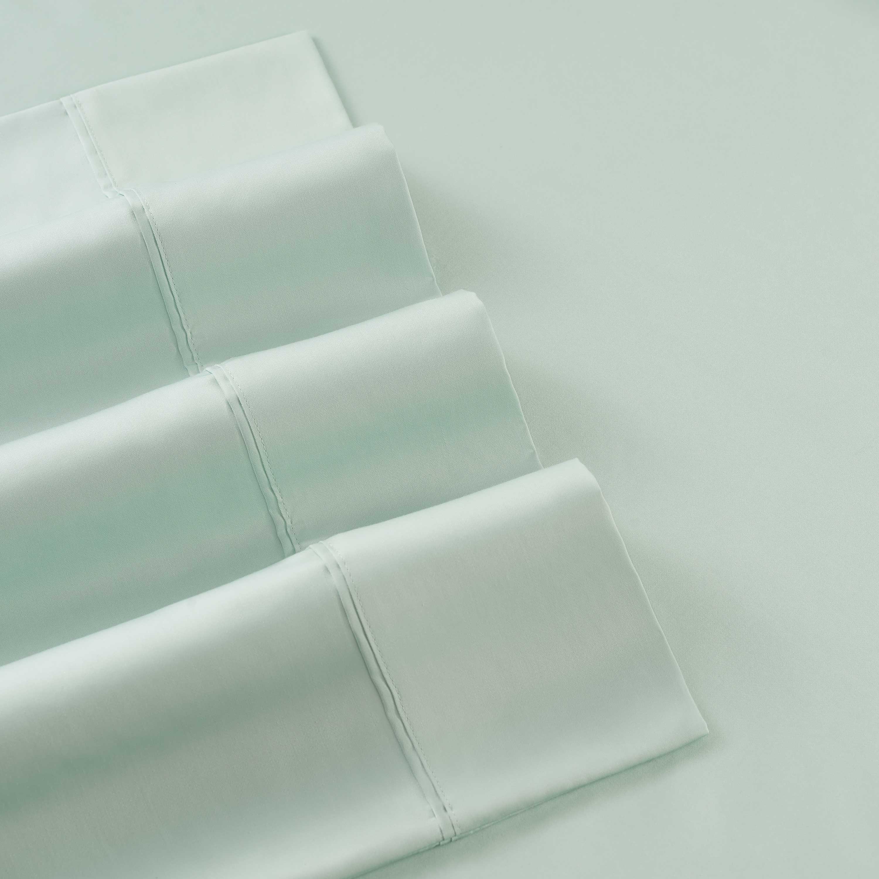 Light green sheets with a smooth texture and folded edges, showcasing a 400 thread count.