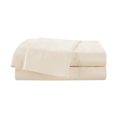 Cream-colored cotton sheet set stacked with a flat sheet on top.