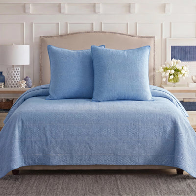 Blue Southern Tide quilt and shams on a bed.