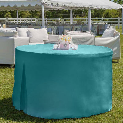 Round table covered with a teal tablecloth, set outdoors with chairs and a decorative centerpiece.