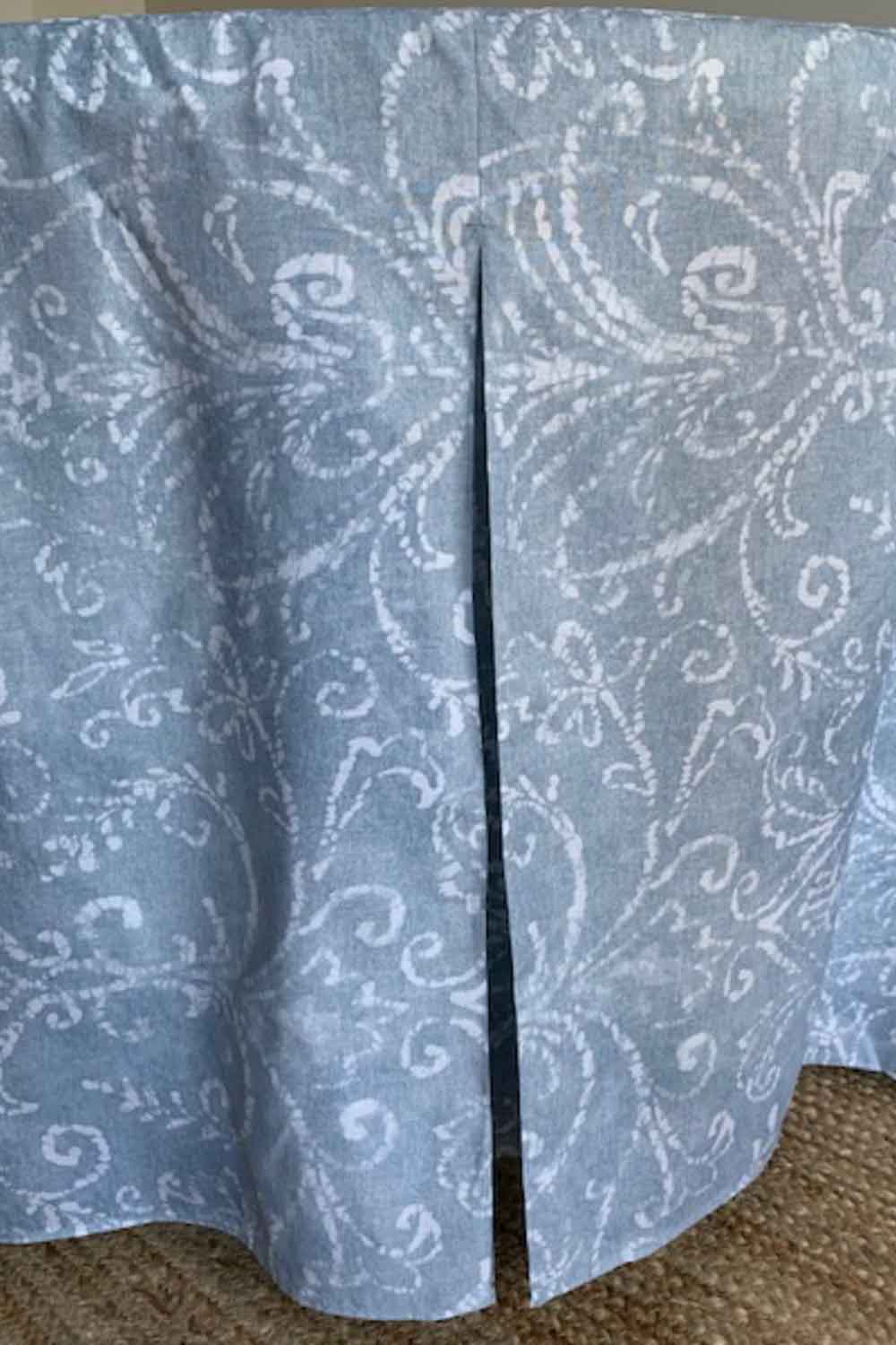 Round table cover with a light blue and white swirling pattern, featuring a slit for easy access.