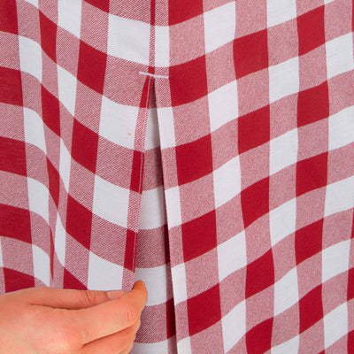 Red and white checkered table cover with a hand adjusting the fabric.